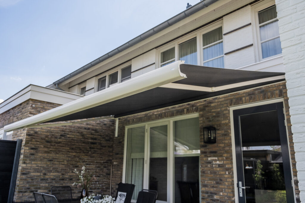 Impressie van een knikarmscherm dat uitgehangen wordt.