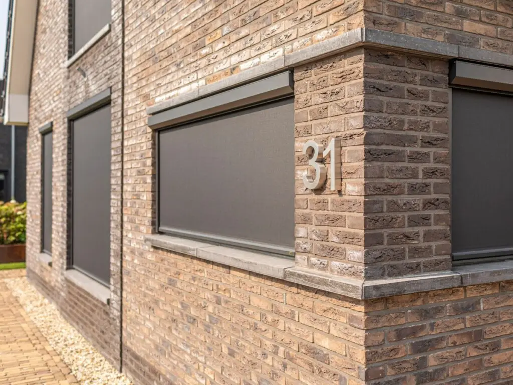 Aanzicht van een woning, voorzien van screens op de beneden- en bovenverdieping.